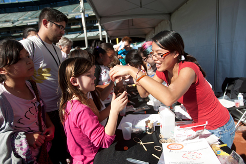 Christie Duong, right, helps Megan Gofron, 10, as she experiments with DNA extraction at one of the UCSF booths at this year's Bay Area Science Festival.