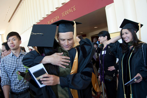 UCSF School of Pharmacy 2012 graduate Patrick Edsall hugs a classmate after the ceremony.