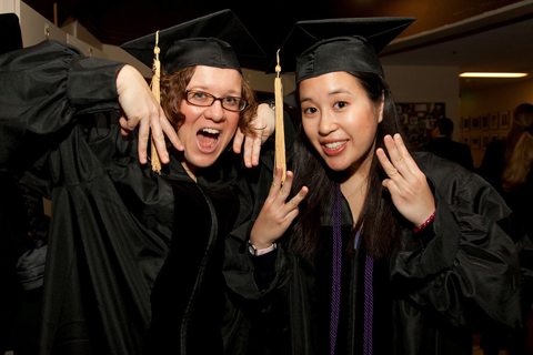 Rebecca Gayle, left, and Justine Lin show their excitement as they prepare to receive their degrees during the pharmacy school commencement.
