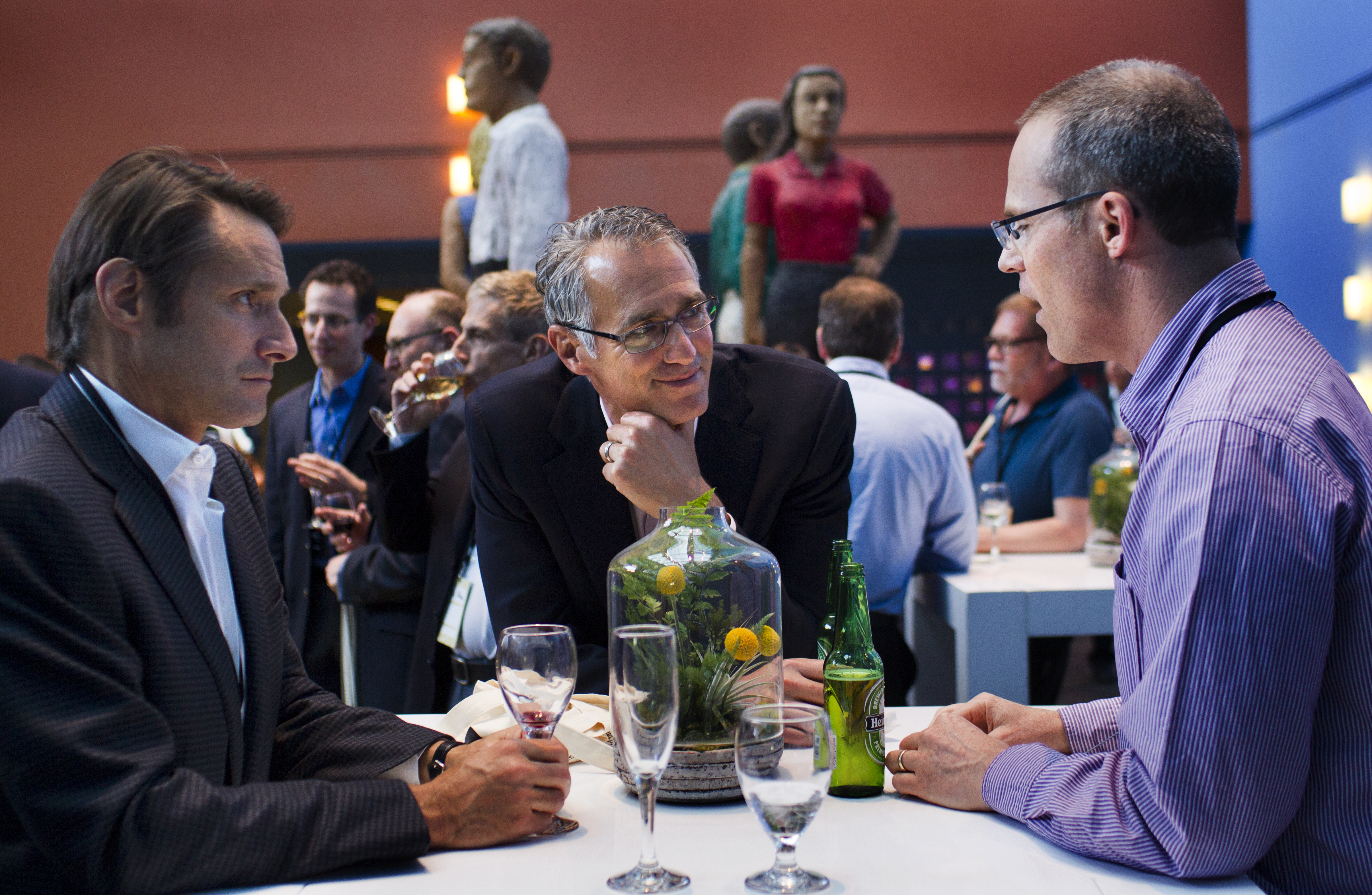 Three summit participants enjoy an opportunity to network at the evening reception in the atrium at the Rutter Center. 