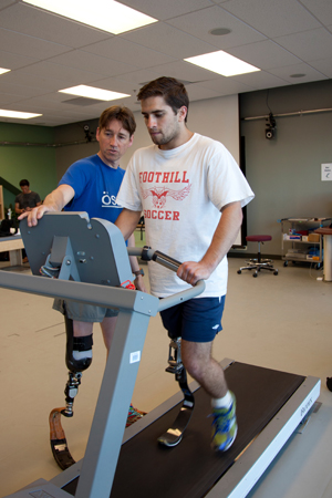 Trainer Jeff Turner looks on as Ranjit Steiner runs on treadmill at UCSF.