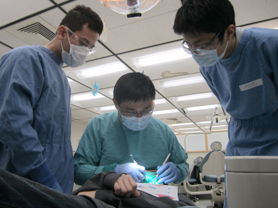Brent Lin, DMD, cleans a patient’s teeth