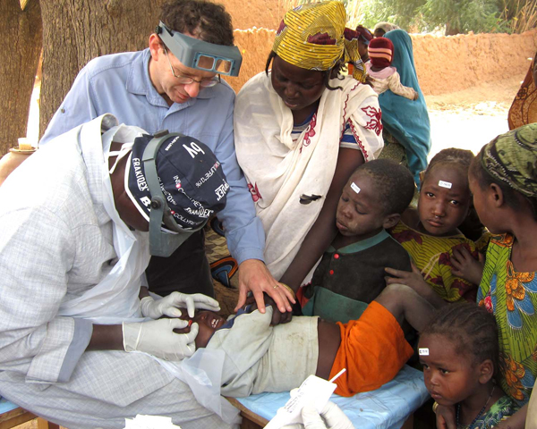 Bruce Gaynor and a colleague examine a young patient in an Ethiopian village.