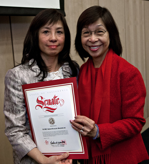 Maxine Yee, right, presents a certificate of recognition.