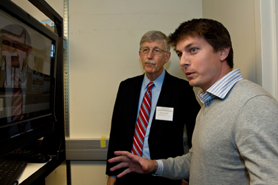 Specialist Kyle Lapham demonstrates the ATLAS robot to Francis Collins