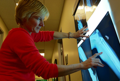 Christina Allen, MD, examines a patient’s X-ray