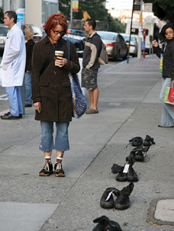 A passerby stops to observe the row of boots along Parnassus Avenue.
