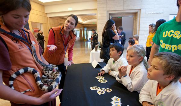 California Academy of Sciences staff show a Northern Pine Snake to children 