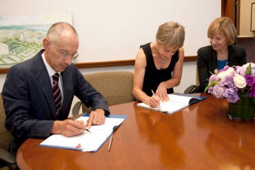 Michael Moritz and Harriet Heyman signing agreement