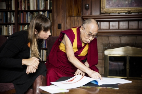 The Dalai Lama and Eve Ekman look at a booj about the Atlas of Emotions