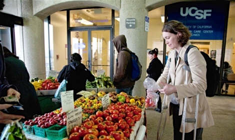 Kathleen Land, a programs analyst at UCSF, shops for fresh produce at UCSF Parnassus' farmers market.