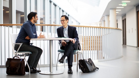 Edward Chang and Vikaas Sohal talk at a table in the Sandler Neurosciences Building