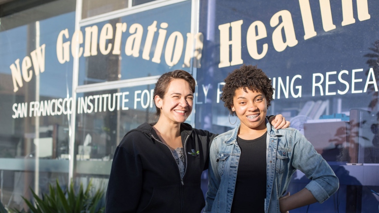 2 women smiling in front of a window that says New Generation Health Center