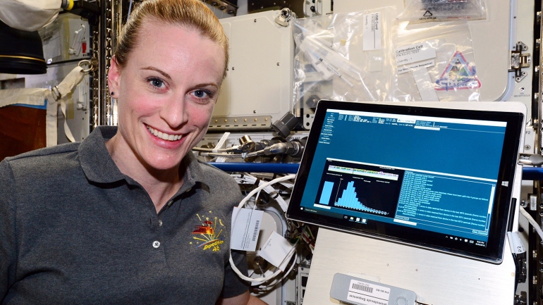 NASA Astronaut Kate Rubins is shown with the MiniON sequencing device aboard the International Space Station.