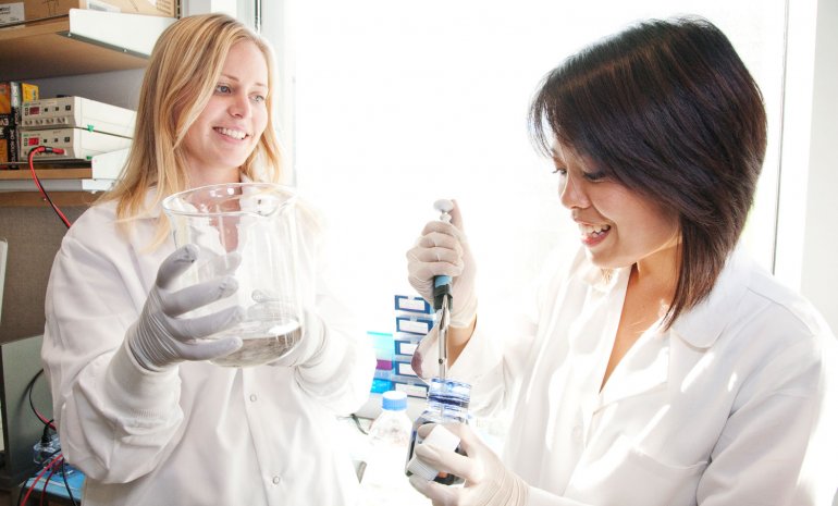 Two researchers work in the lab at the Helen Diller Comprehesive Cancer Center