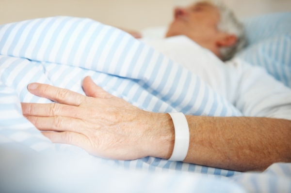 Stock photo of elderly patient in hospital bed