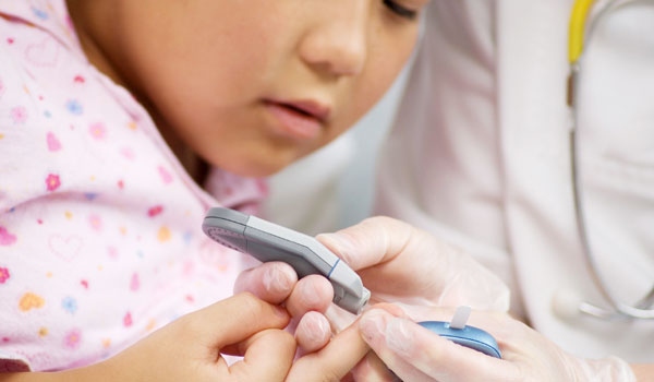 doctor performs diabetes test on a child.