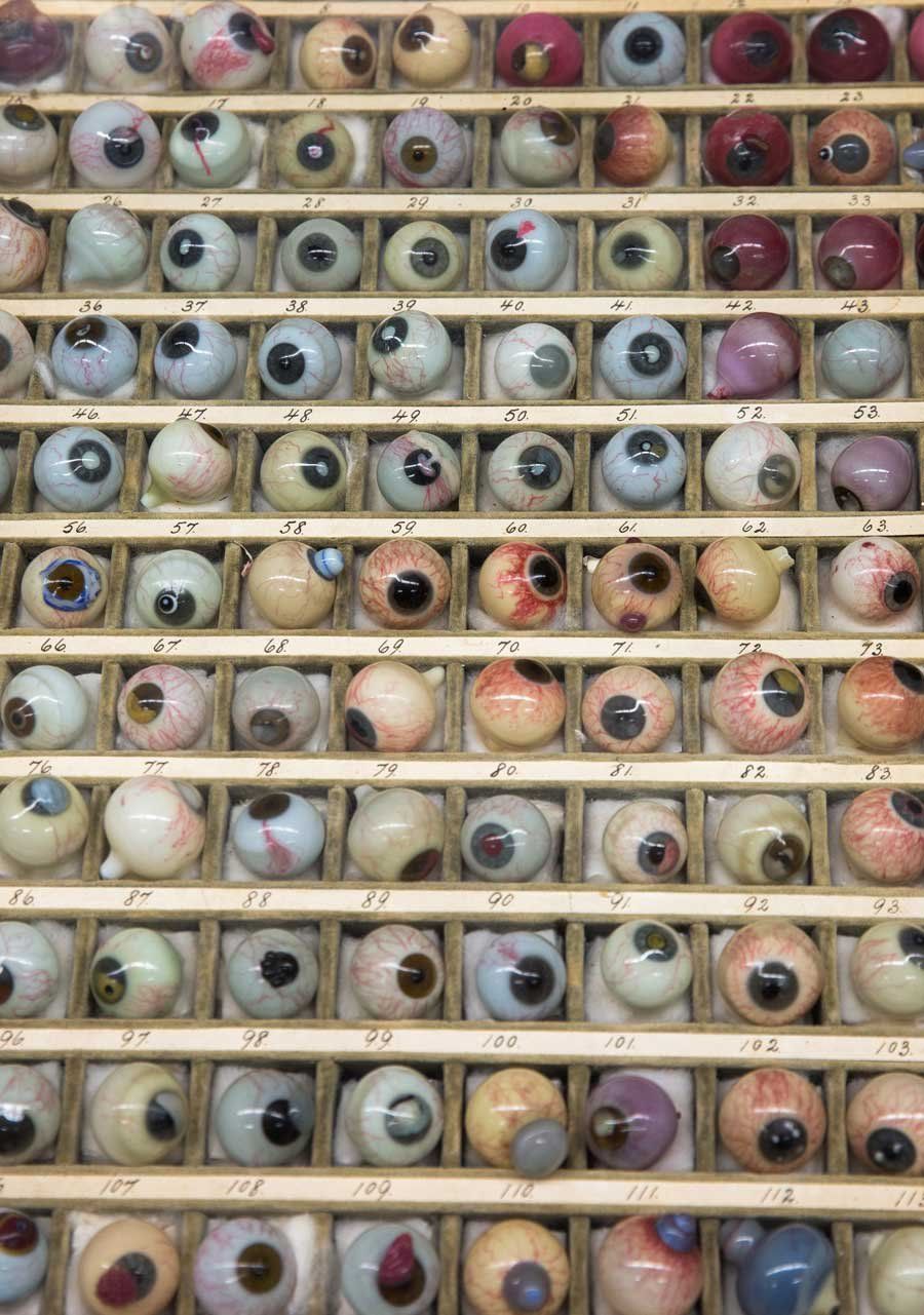 A display case shows a collection of hundreds of glass blown prosthetic eyeballs.