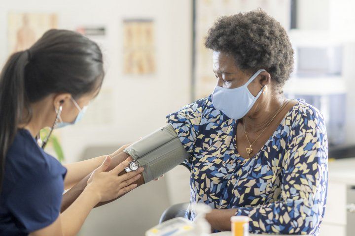 Black woman has her blood pressure taken by a nurse
