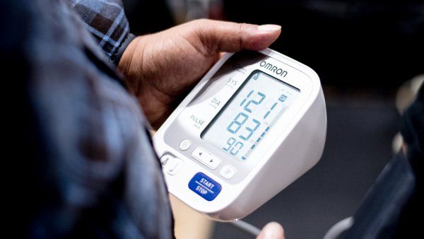 Hands holding blood pressure monitor