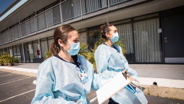 two nursing students walk through a hotel parking lot