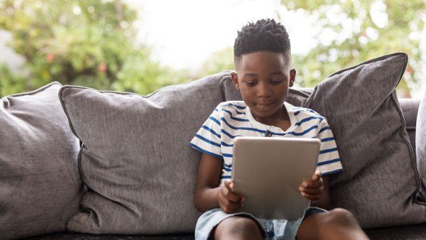 Boy sitting on couch using a tablet