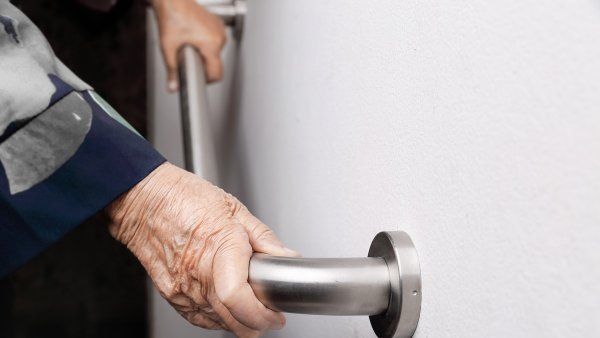 closeup of elderly hands holding a safety bar