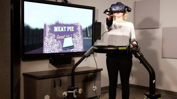 woman wears a VR headset while walking on a treadmill machine