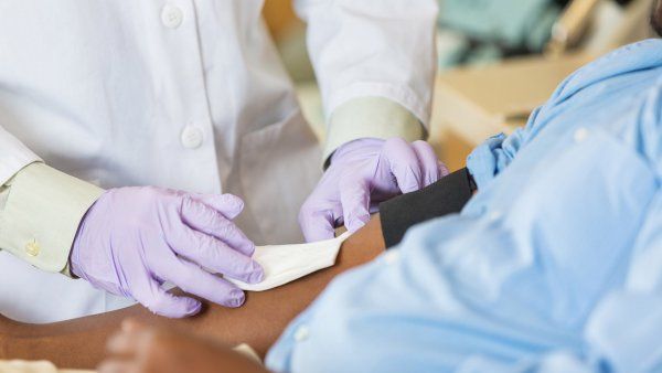 nurse prepares man for a blood draw