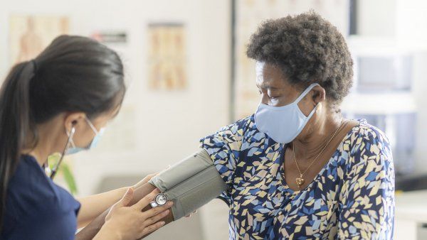 Black woman has her blood pressure taken by a nurse