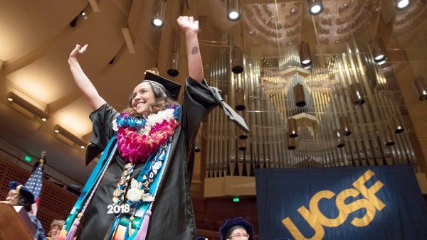 Gabriela Chica raises her arms in celebration at the School of Nursing commencement ceremony