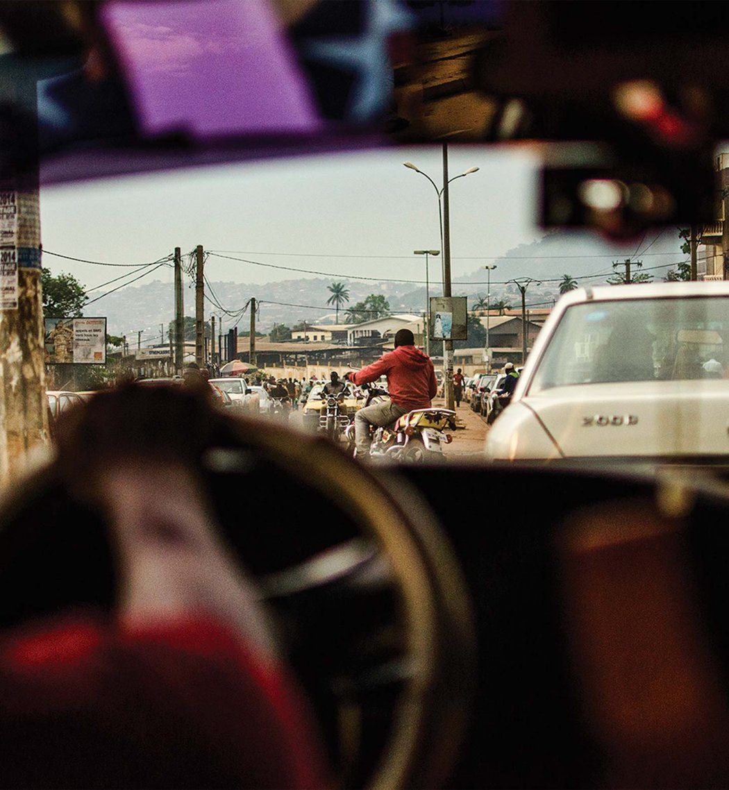 Photo from the inside of a car, looking out over a busy street.