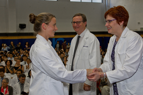 Catherine Lucey, MD, vice dean of education, and Dean Hawgood congratulates a new medical student.