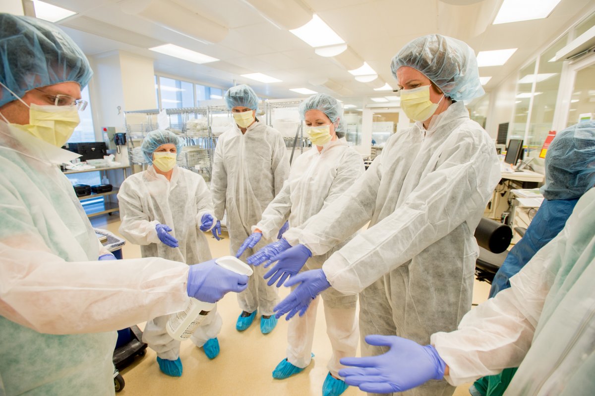 A group of people in disposable surgical scrubs and gloves.