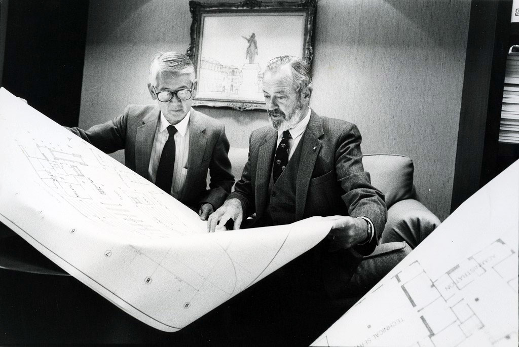 two men look at architectural plans