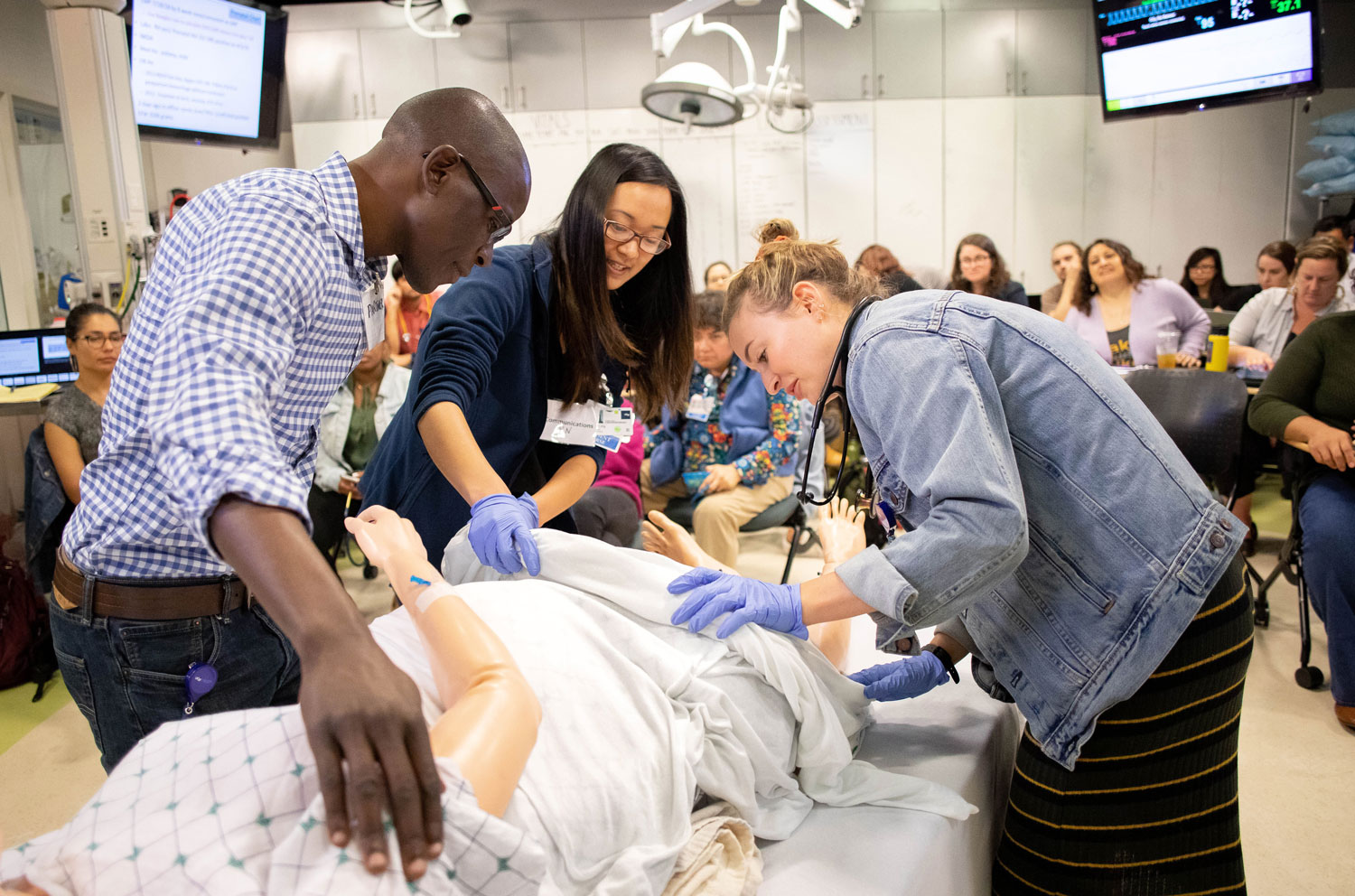 Nursing students working on mannequin of pregnant patient