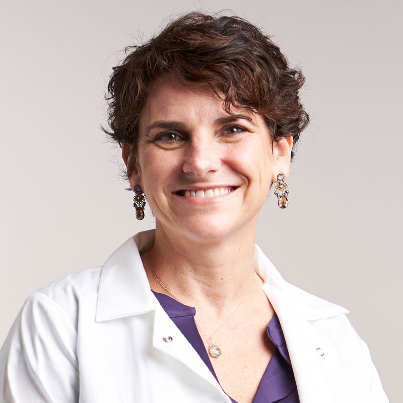 Michelle Arkin, PhD, stands for a portrait in a white lab coat