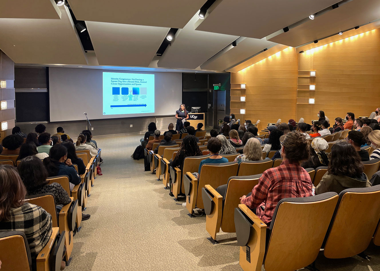 A lecture room is filled with attendees listening to Dr. D'Anne Duncan present the 2022 UCSF Last Lecture.