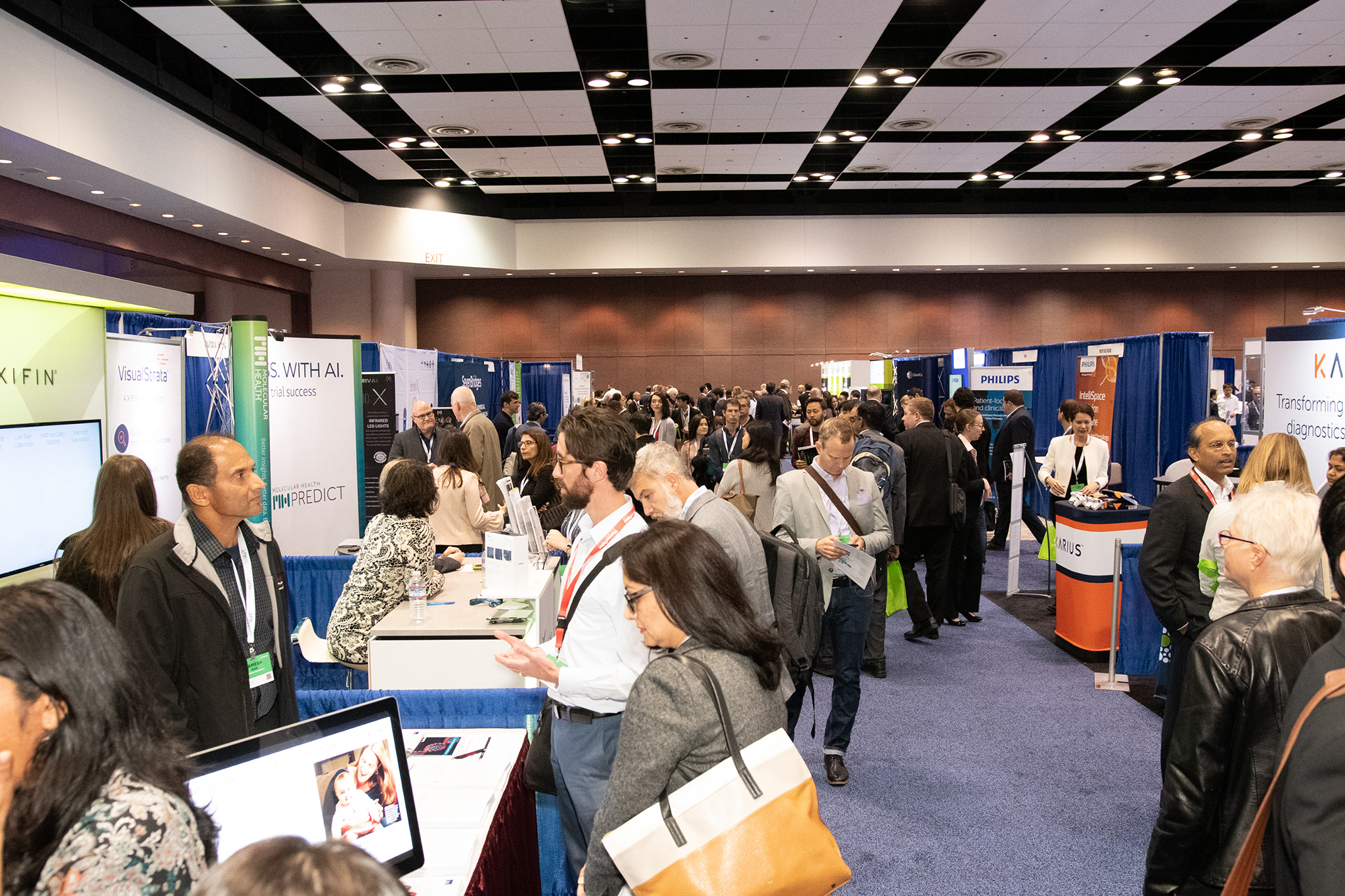 Attendees visit booths at a conference center at the 2019 Precision Medicine World Conference
