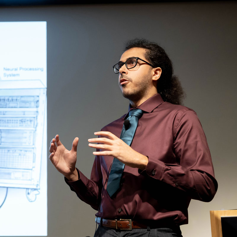 Postdoctoral student David Moses presents research onstage