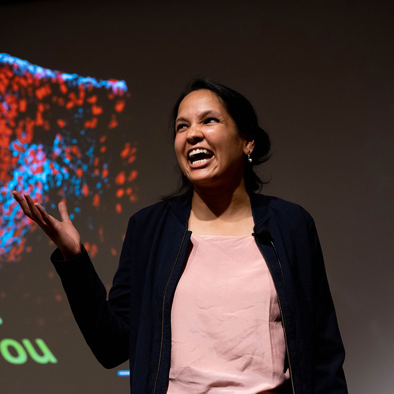 Postdoctoral student Neha Pricha Schoff presents research onstage