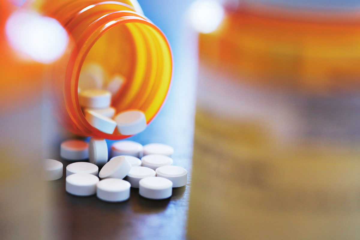 A photo of pills coming out of a pill bottle