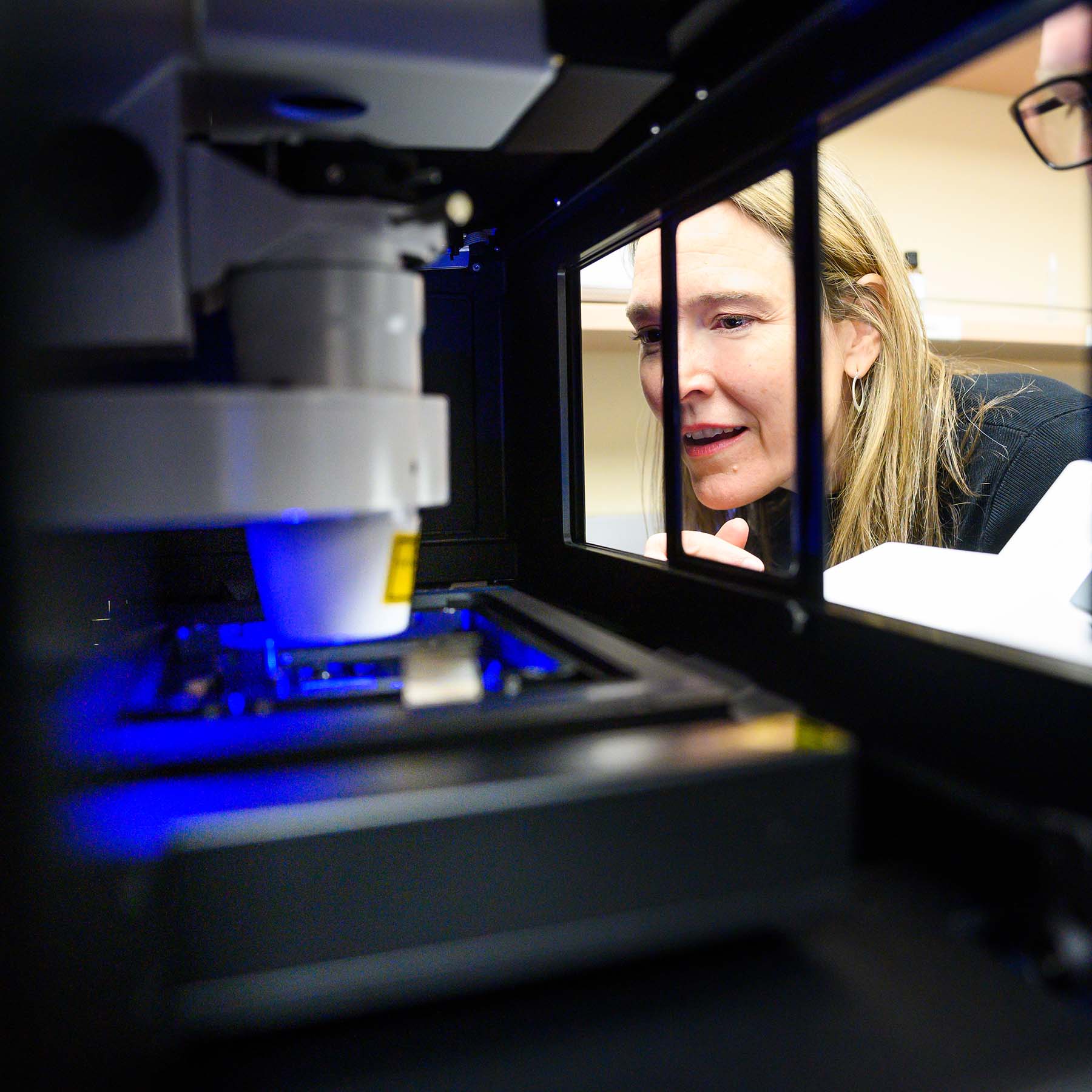 Leanne Jones peers into a chamber that contains a high-powered microscope