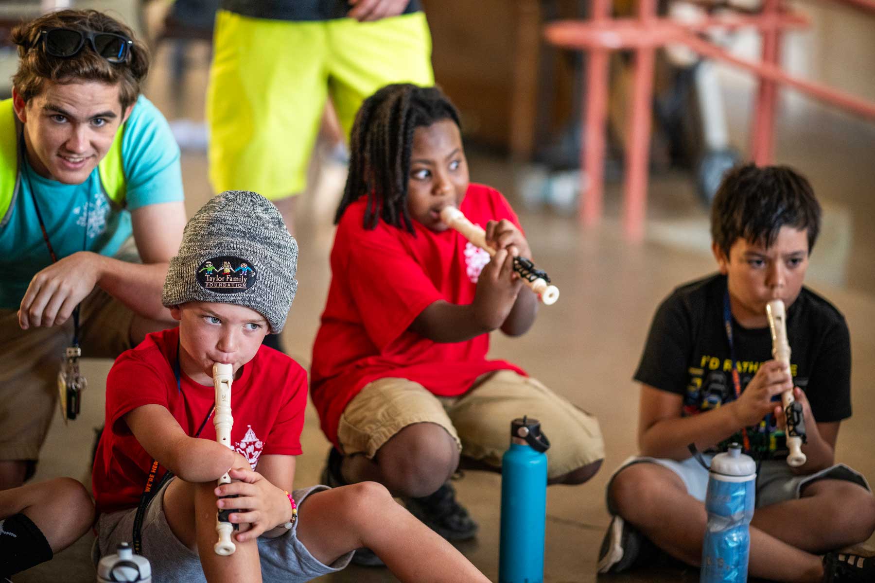 A diverse group of children with limb differences play music on adaptive recorders.