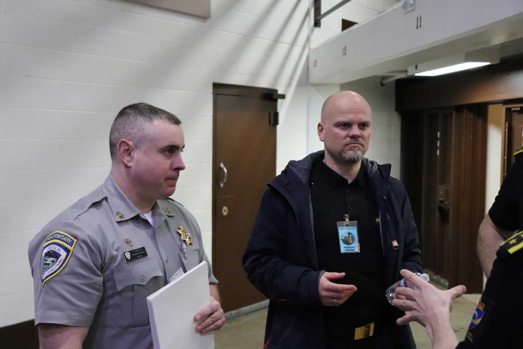 Toby Tooley, a former prison captian, wears his officer uniform as he stands with members of the Norwegian Correctional Service team inside a prison.