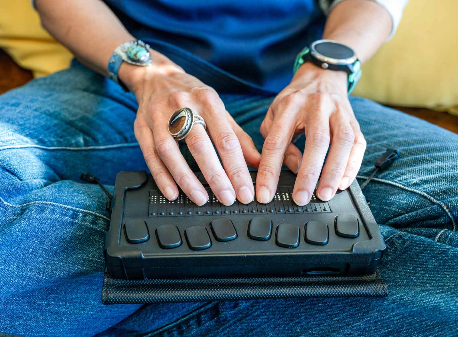 Angela woon uses a braile e-reader, which is a rectangular device with ten buttons for each finger, and braile.