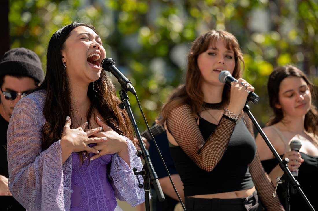 A group of female musicians sing and perform live music.