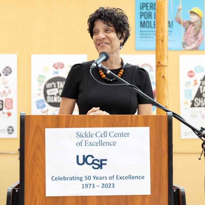 Marsha Treadwell speaks at a podium at the Sickle Cell Center of Excellence's 50th anniversary.