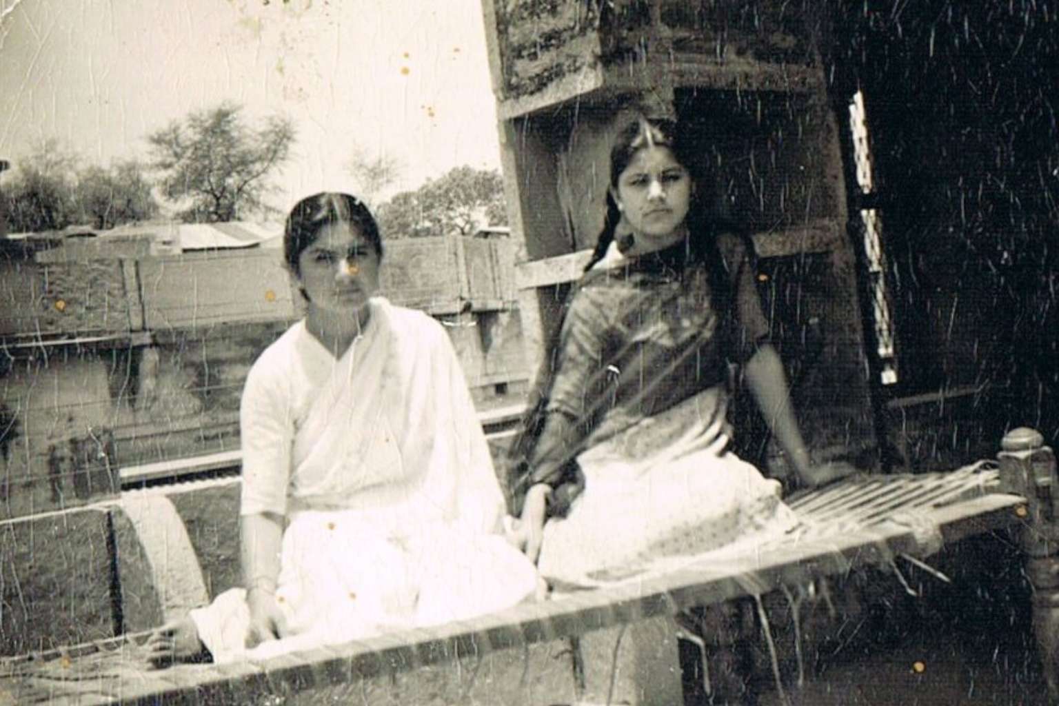 black and white very old photograph of two young women wearing Indian clothing