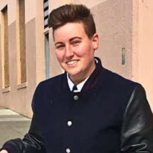 nick wears suit coat smiling